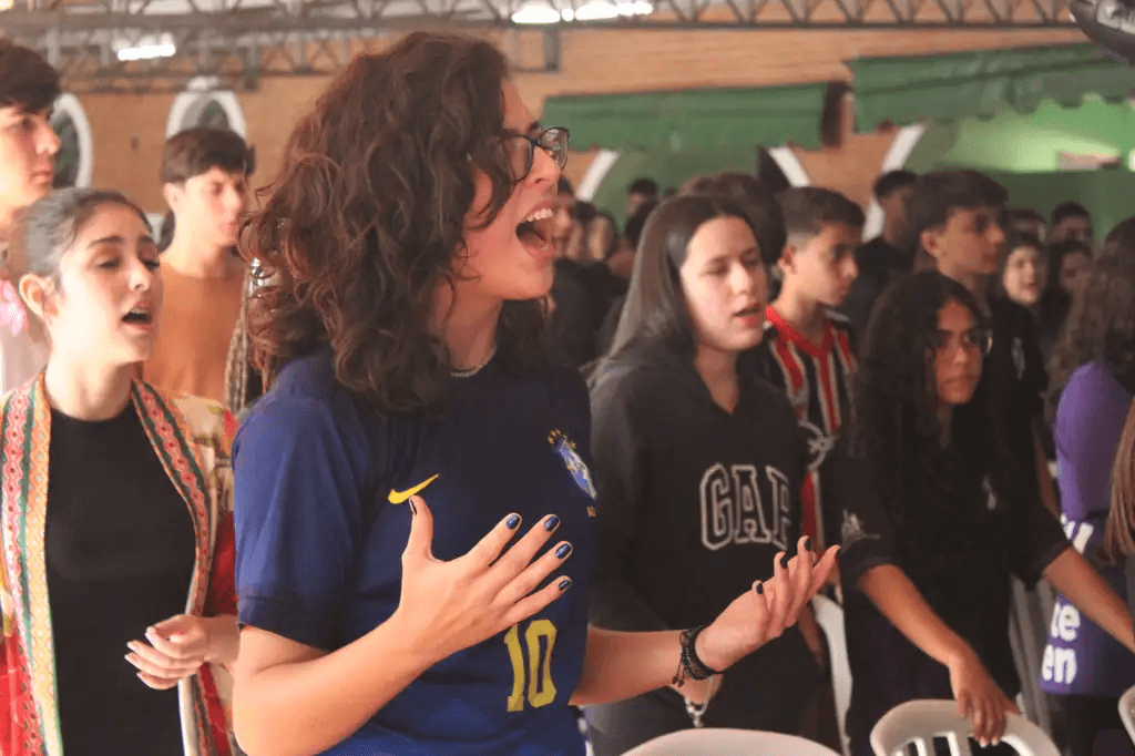 Adolescentes em um momento de louvor no Jubateen